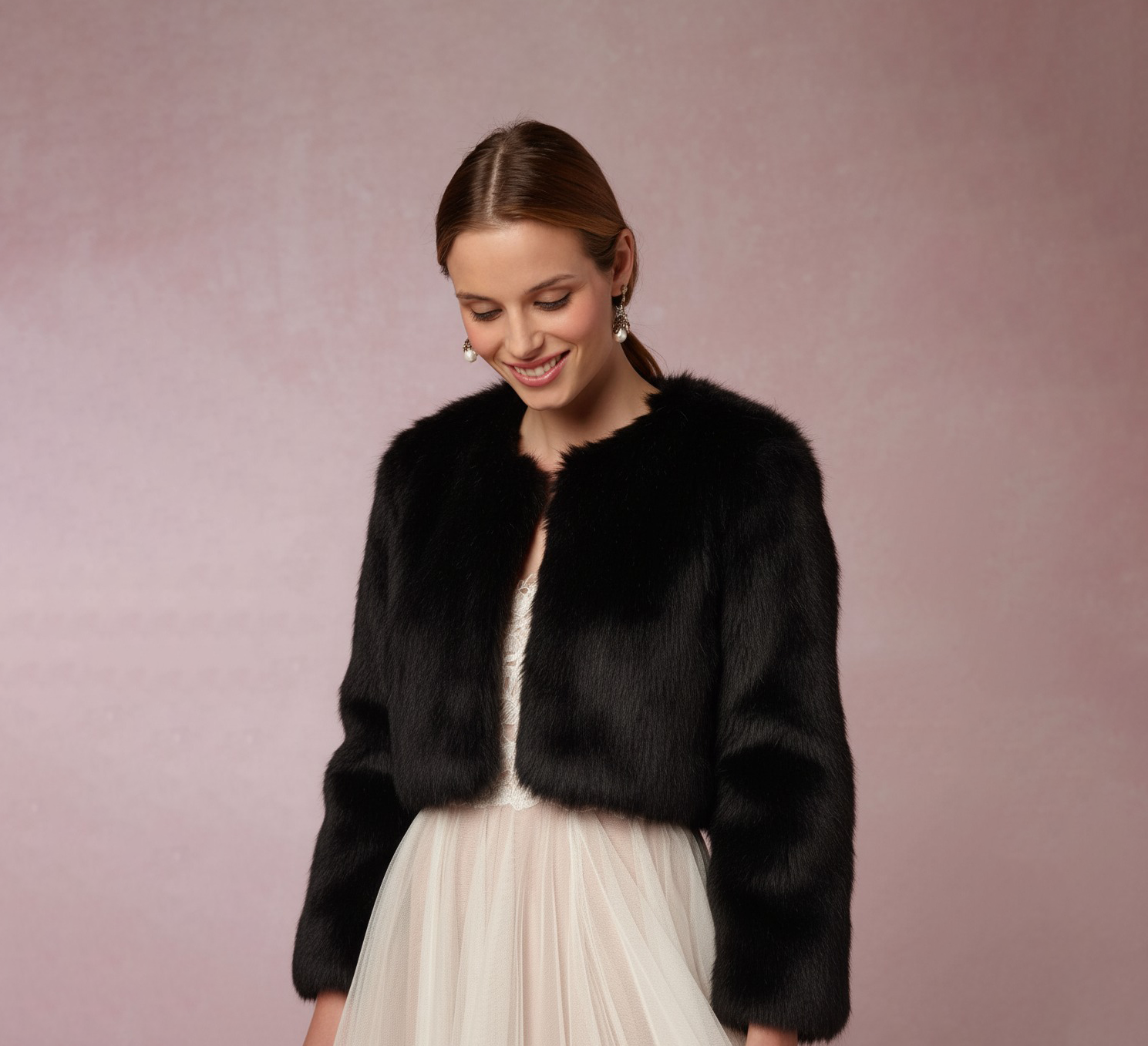 Mujer elegante con abrigo de peluche sintética negro, mirando a la cámara con pose natural y suave expresión. Abrigo de novia, estola negra, moda invierno, vestidos de fiesta, accesorios de boda.
